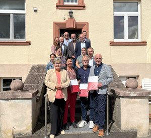 Zu sehen sind Staatsekretärin Brück, Landrat Kruppert sowie Vertreterinnen und Vertreter des Eifelkreis Bitbrug-Prüm.