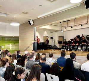 Das Foto zeigt Ministerin Hubig auf der Bühne der Aula, während sie die neuen Fünftklässlerinnen und Fünftklässler begrüßt. 