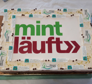 Das Foto zeigt eine Torte mit dem Logo: MINT läuft 