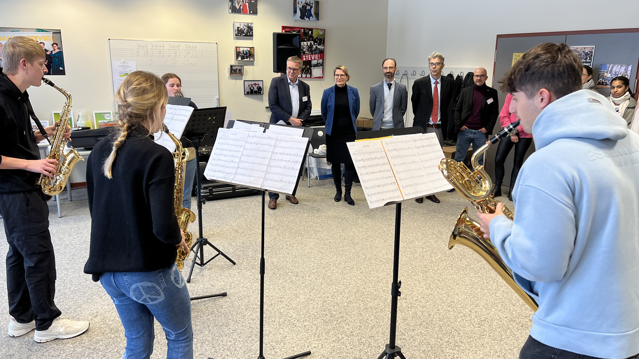 Auf dem Bild ist eine Jazz-Gruppe zu sehen, die vor Lehrerinnen und Lehrern, sowie der Ministerin spielt. 